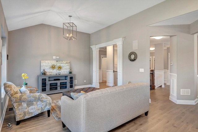 8830 Indiana Harbor Dr, Frankfort, IL 60423 - living area featuring decorative columns, light wood-type flooring, vaulted ceiling, wainscoting, and a chandelier