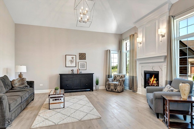 8830 Indiana Harbor Dr, Frankfort, IL 60423 - living area featuring a chandelier, light wood-style flooring, baseboards, a fireplace, and high vaulted ceiling