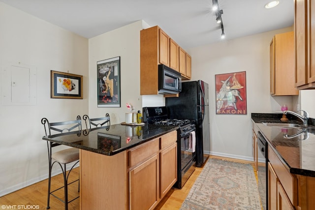 6100 N Rockwell St Unit 3S, Chicago, IL 60659 - kitchen featuring black appliances, a sink, a kitchen breakfast bar, a peninsula, and dark stone countertops