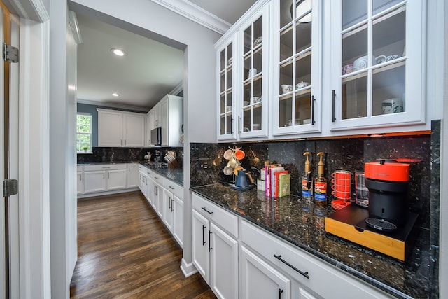 3095 Long Common Pkwy, Elgin, IL 60124 - kitchen with crown molding, dark wood-style flooring, dark stone countertops, tasteful backsplash, and glass insert cabinets