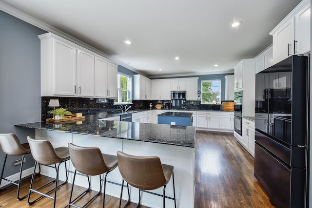 3095 Long Common Pkwy, Elgin, IL 60124 - kitchen featuring black appliances, a peninsula, dark wood-style floors, backsplash, and crown molding