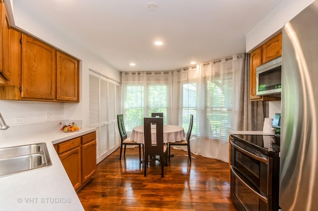 75 Willow Pkwy, Buffalo Grove, IL 60089 - kitchen featuring appliances with stainless steel finishes, light countertops, dark wood-style floors, brown cabinets, and recessed lighting