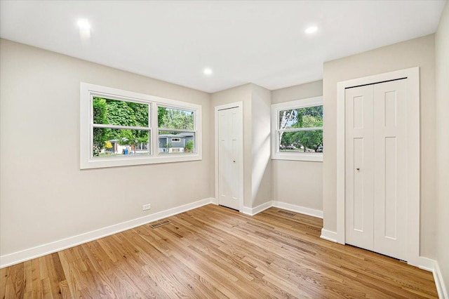 114 S Waverly Pl, Mount Prospect, IL 60056 - unfurnished bedroom featuring multiple closets, multiple windows, light wood-style floors, and recessed lighting