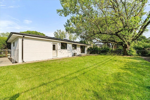 114 S Waverly Pl, Mount Prospect, IL 60056 - rear view of property with a chimney, a fenced backyard, and brick siding