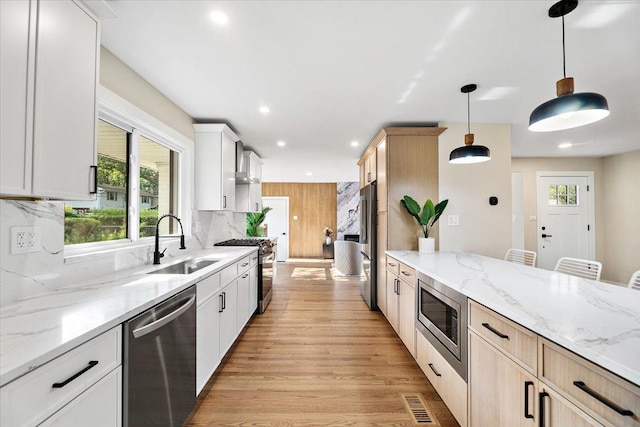 114 S Waverly Pl, Mount Prospect, IL 60056 - kitchen with stainless steel appliances, wall chimney range hood, light wood finished floors, hanging light fixtures, and recessed lighting