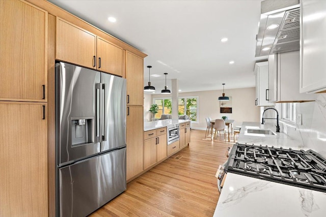 114 S Waverly Pl, Mount Prospect, IL 60056 - kitchen with appliances with stainless steel finishes, light brown cabinetry, light wood finished floors, exhaust hood, and decorative light fixtures