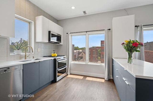 1645 W Erie St Unit 2, Chicago, IL 60622 - kitchen featuring appliances with stainless steel finishes, light wood-type flooring, decorative backsplash, light countertops, and recessed lighting