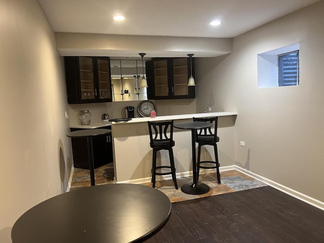 4429 203rd St, Matteson, IL 60443 - kitchen featuring wood finished floors, glass insert cabinets, a breakfast bar area, baseboards, and light countertops