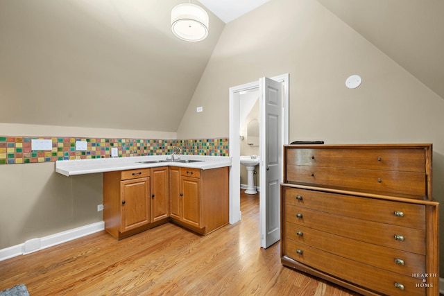 275 S Mchenry Ave, Crystal Lake, IL 60014 - kitchen featuring a sink, vaulted ceiling, light wood-style floors, tasteful backsplash, and brown cabinetry