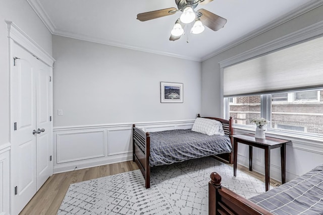5021 N Kenmore Ave Unit 1S, Chicago, IL 60640 - bedroom featuring light wood-type flooring, crown molding, wainscoting, and a ceiling fan