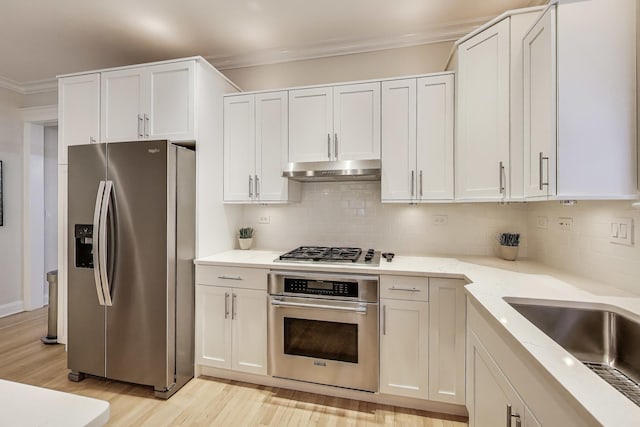5021 N Kenmore Ave Unit 1S, Chicago, IL 60640 - kitchen featuring appliances with stainless steel finishes, under cabinet range hood, ornamental molding, light wood-style floors, and tasteful backsplash