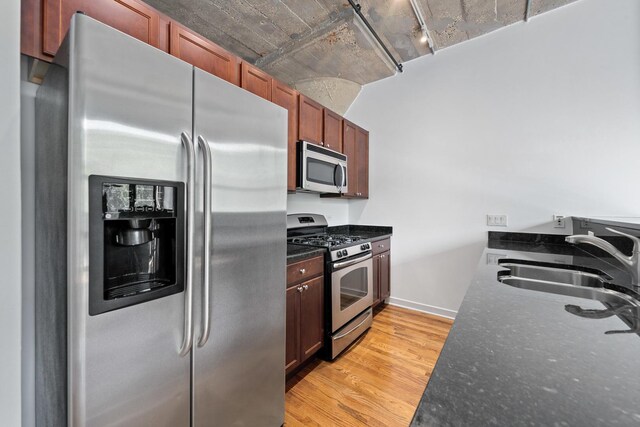 1150 W 15th St Unit 232, Chicago, IL 60608 - kitchen with appliances with stainless steel finishes, a sink, light wood-type flooring, baseboards, and dark stone countertops