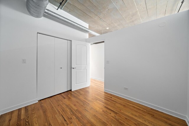 1150 W 15th St Unit 232, Chicago, IL 60608 - unfurnished bedroom with wood finished floors, a closet, and baseboards