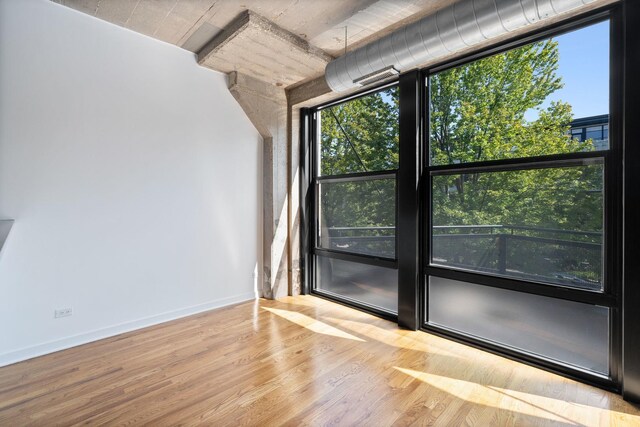 1150 W 15th St Unit 232, Chicago, IL 60608 - unfurnished room with healthy amount of natural light, wood finished floors, and baseboards