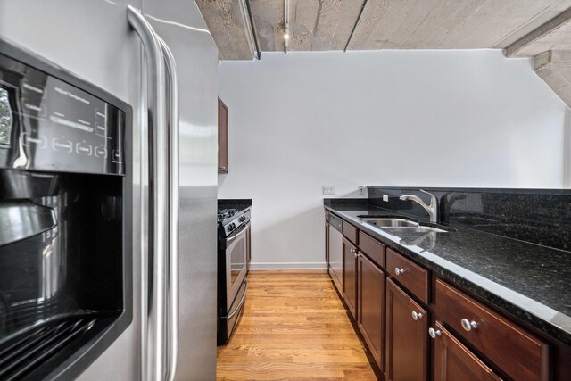 1150 W 15th St Unit 232, Chicago, IL 60608 - kitchen featuring appliances with stainless steel finishes, a sink, light wood-style flooring, dark stone counters, and baseboards
