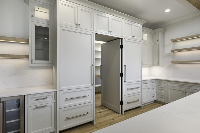 845 Tulip Ln, Naperville, IL 60540 - kitchen with wine cooler, open shelves, light wood-style flooring, decorative backsplash, and glass insert cabinets