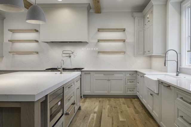 845 Tulip Ln, Naperville, IL 60540 - kitchen featuring open shelves, a sink, stainless steel microwave, light wood-style floors, and beam ceiling