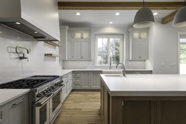845 Tulip Ln, Naperville, IL 60540 - kitchen featuring range with two ovens, wall chimney exhaust hood, a sink, light wood-style floors, and recessed lighting