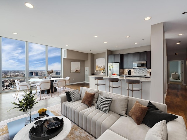 living room featuring dark wood-type flooring, recessed lighting, a wall of windows, and baseboards