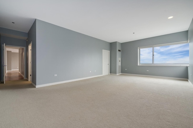 spare room featuring light colored carpet, baseboards, and recessed lighting