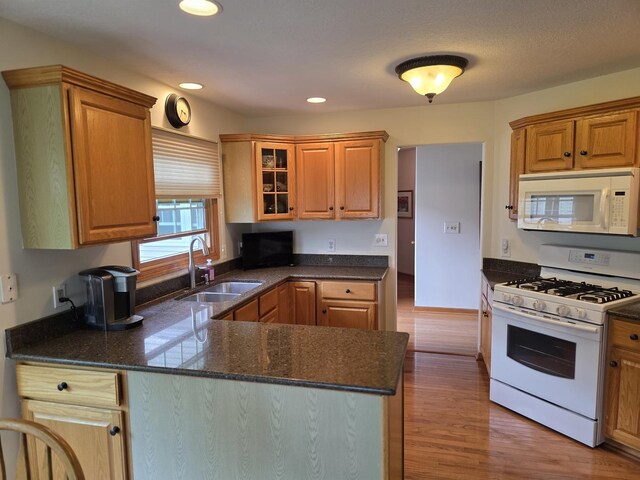 873 Beauchamp Ave, Manteno, IL 60950 - kitchen with white appliances, a peninsula, wood finished floors, glass insert cabinets, and recessed lighting