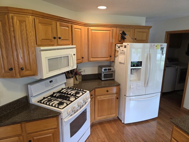 873 Beauchamp Ave, Manteno, IL 60950 - kitchen with white appliances, dark wood-type flooring, recessed lighting, brown cabinets, and dark stone counters