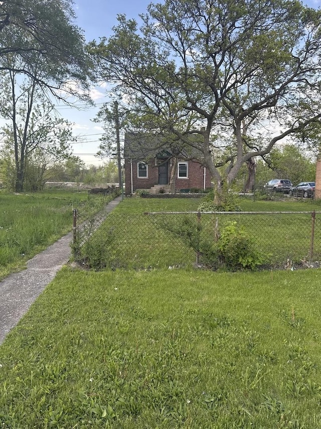128 W 115th St, Chicago, IL 60628 - view of front of house featuring brick siding and a front yard