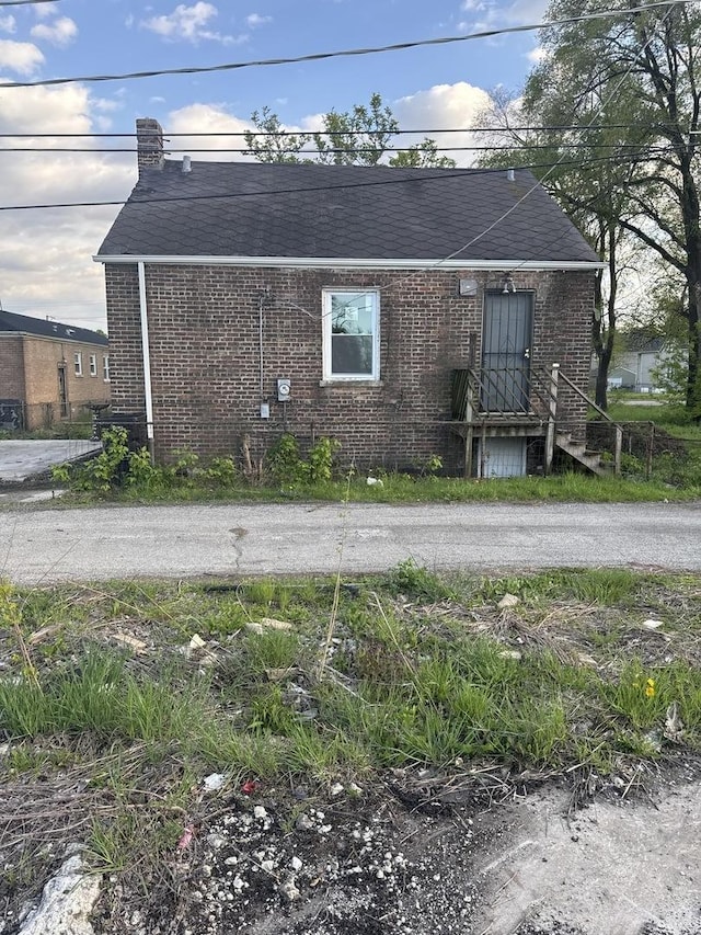 128 W 115th St, Chicago, IL 60628 - view of property exterior featuring brick siding and a shingled roof