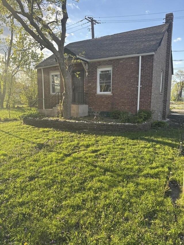 128 W 115th St, Chicago, IL 60628 - ranch-style house with brick siding, a front yard, and a chimney