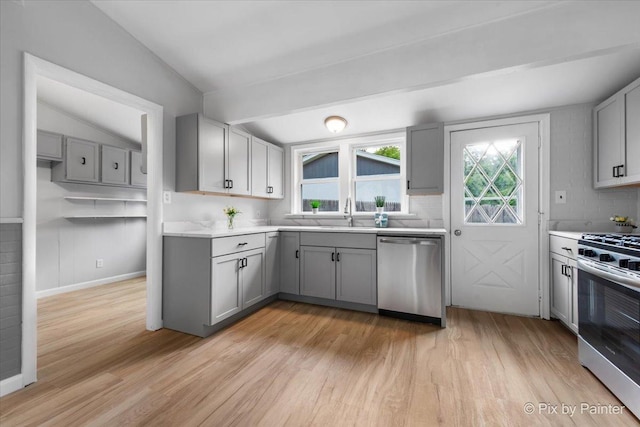 1912 Oakleaf Dr, Mchenry, IL 60050 - kitchen featuring stainless steel appliances, gray cabinetry, light wood-style flooring, lofted ceiling, and light countertops