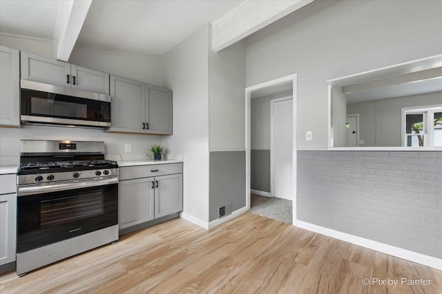 1912 Oakleaf Dr, Mchenry, IL 60050 - kitchen with appliances with stainless steel finishes, gray cabinetry, beam ceiling, light wood-type flooring, and light countertops