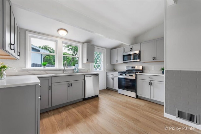 1912 Oakleaf Dr, Mchenry, IL 60050 - kitchen with appliances with stainless steel finishes, a sink, light wood-type flooring, gray cabinets, and light countertops