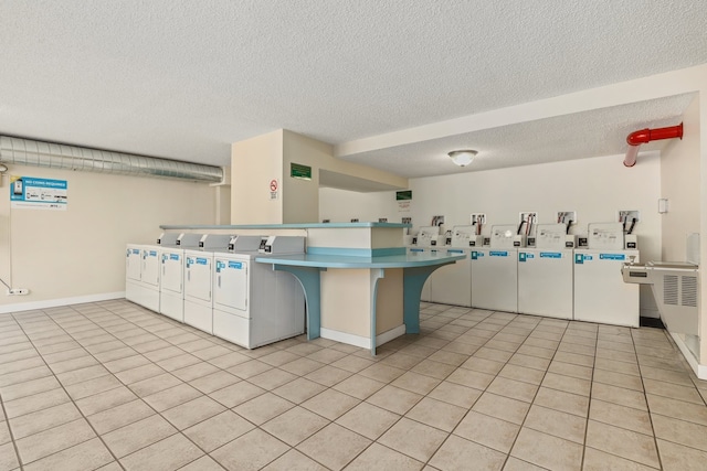 2754 N Hampden Ct Unit 2002, Chicago, IL 60614 - kitchen with washer and clothes dryer, a textured ceiling, a peninsula, light tile patterned floors, and a breakfast bar