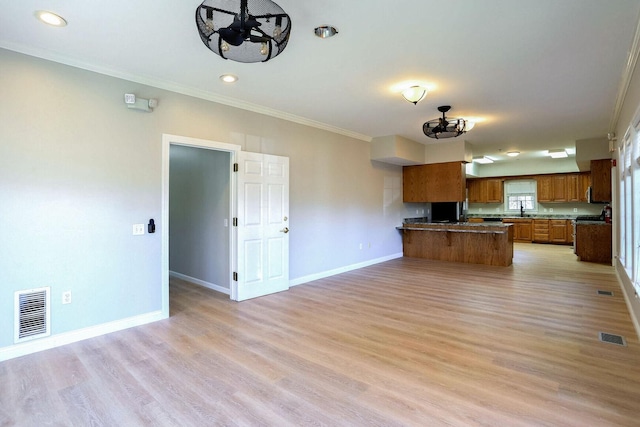 504 E Church St, Champaign, IL 61820 - kitchen with brown cabinetry, open floor plan, refrigerator, crown molding, and a peninsula