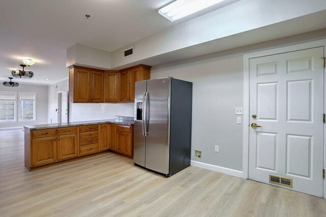 504 E Church St, Champaign, IL 61820 - kitchen featuring stainless steel fridge, brown cabinets, light wood-style floors, and a peninsula