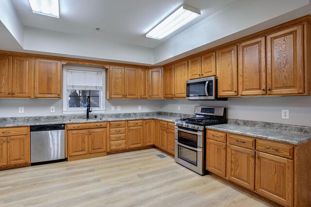 504 E Church St, Champaign, IL 61820 - kitchen featuring appliances with stainless steel finishes, a sink, and brown cabinets