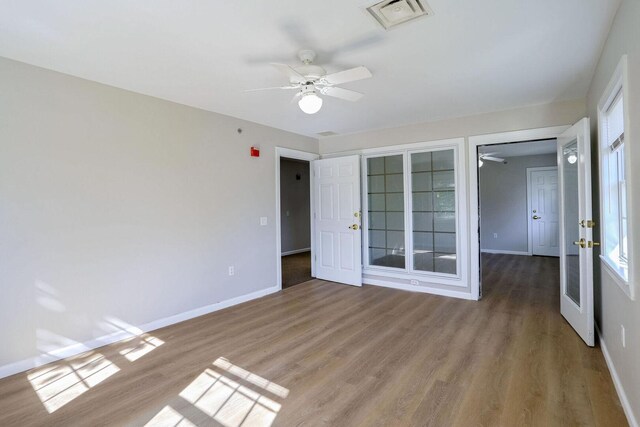 504 E Church St, Champaign, IL 61820 - unfurnished bedroom with baseboards, wood finished floors, and multiple windows