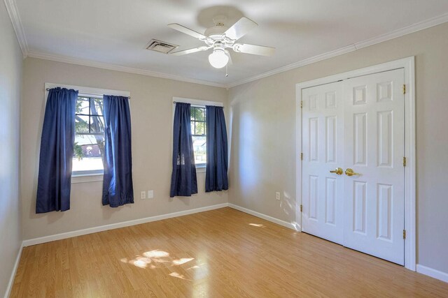504 E Church St, Champaign, IL 61820 - unfurnished bedroom with light wood-style floors, baseboards, ornamental molding, a closet, and a ceiling fan