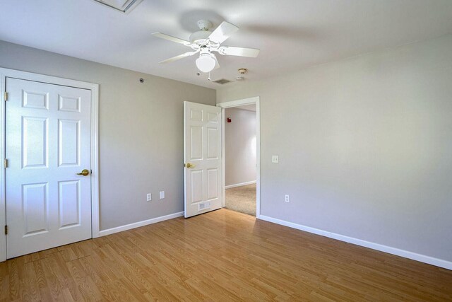 504 E Church St, Champaign, IL 61820 - unfurnished bedroom with light wood finished floors, baseboards, and ceiling fan