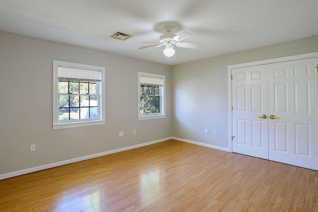 504 E Church St, Champaign, IL 61820 - unfurnished bedroom with light wood finished floors, baseboards, a closet, and ceiling fan