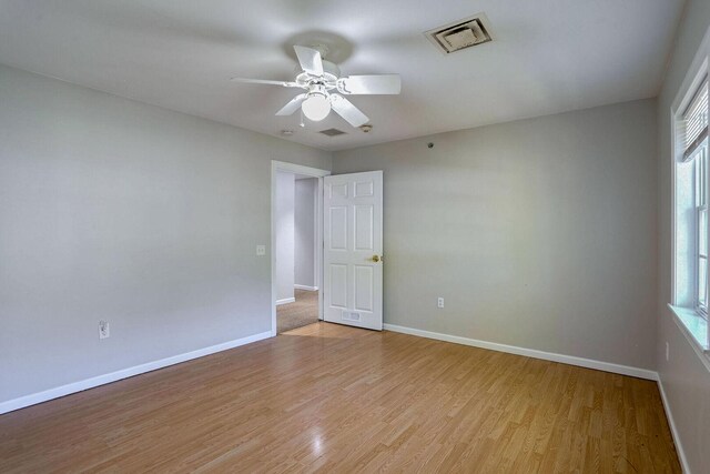 504 E Church St, Champaign, IL 61820 - spare room featuring baseboards, light wood-style flooring, and a ceiling fan