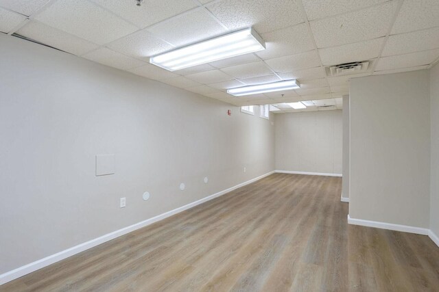 504 E Church St, Champaign, IL 61820 - unfurnished room featuring wood finished floors, a paneled ceiling, and baseboards