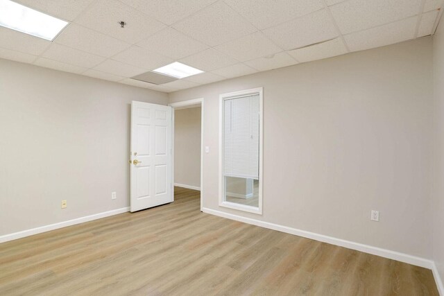 504 E Church St, Champaign, IL 61820 - empty room with a drop ceiling, light wood-style floors, baseboards, and a pendent fire sprinkler