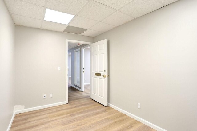 504 E Church St, Champaign, IL 61820 - spare room featuring light wood-style floors, a paneled ceiling, and baseboards