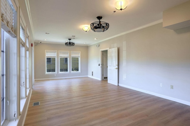 504 E Church St, Champaign, IL 61820 - unfurnished room featuring crown molding, baseboards, light wood-style floors, and a chandelier