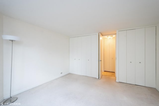 535 N Michigan Ave Unit 1808, Chicago, IL 60611 - unfurnished bedroom featuring two closets, light colored carpet, and baseboards