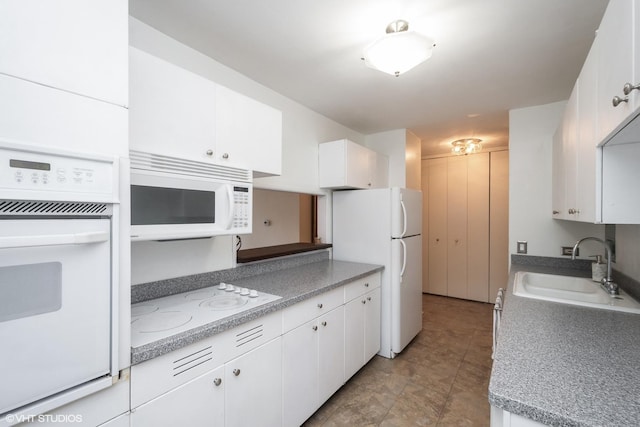 535 N Michigan Ave Unit 1808, Chicago, IL 60611 - kitchen with white appliances, a sink, white cabinets, and light countertops