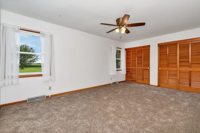 1635 N 4012th Rd, Earlville, IL 60518 - unfurnished bedroom with multiple closets, carpet, and ceiling fan