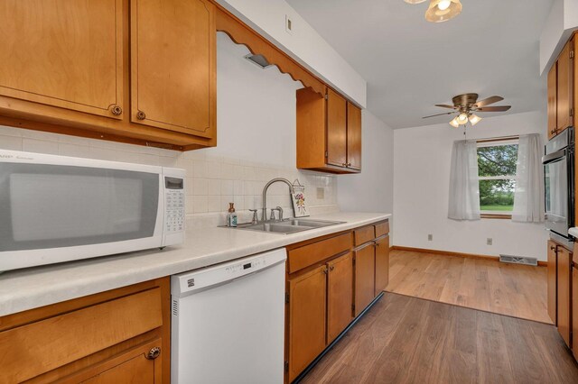 1635 N 4012th Rd, Earlville, IL 60518 - kitchen with white appliances, wood finished floors, brown cabinetry, decorative backsplash, and light countertops