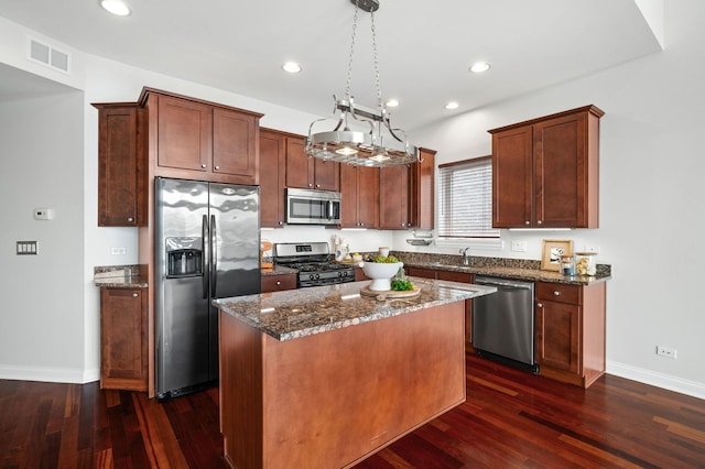 2847 N Pulaski Rd Unit 3S, Chicago, IL 60641 - kitchen with stainless steel appliances, dark stone countertops, dark wood-style floors, a center island, and recessed lighting